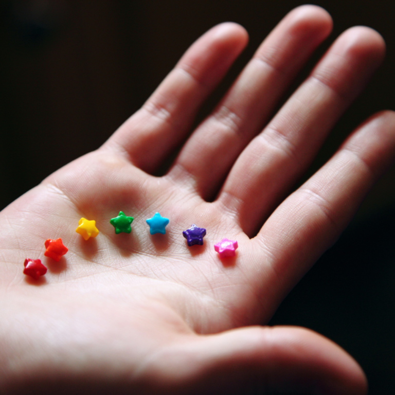 De petites étoiles multicolores dans une main bienveillante.