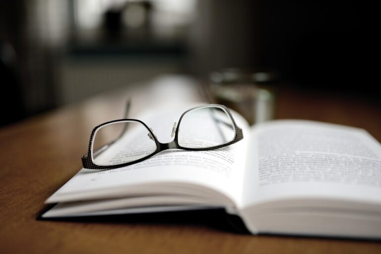 Des lunettes posées sur un livre ouvert.