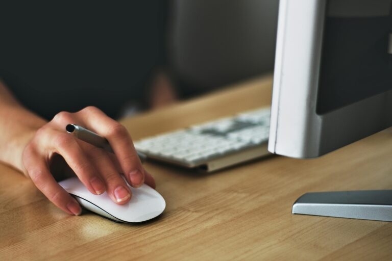 Une main sur une souris d'ordinateur pour contacter un conseiller pro.